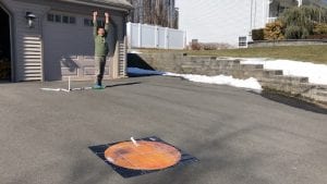 boy with hands over his head and excited expression on his face while toy rocket lies on mars map in his driveway