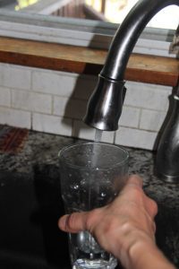 filling a glass with water at a sink