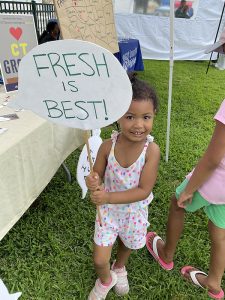 little girl holding a sign that says fresh is best