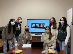 group of girls wearing masks with their screen that says Escape Room