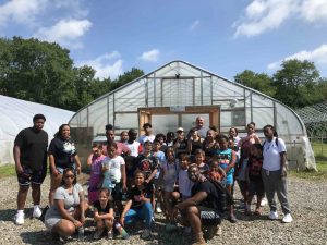 Mashantucket youth in front of the hydroponic greenhouse