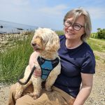 portrait of Joanna Woodward sitting at a state park with her dog