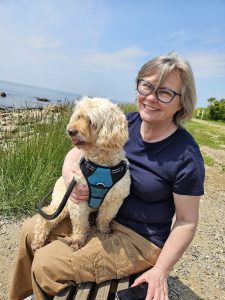 portrait of Joanna Woodward on the beach with a dog