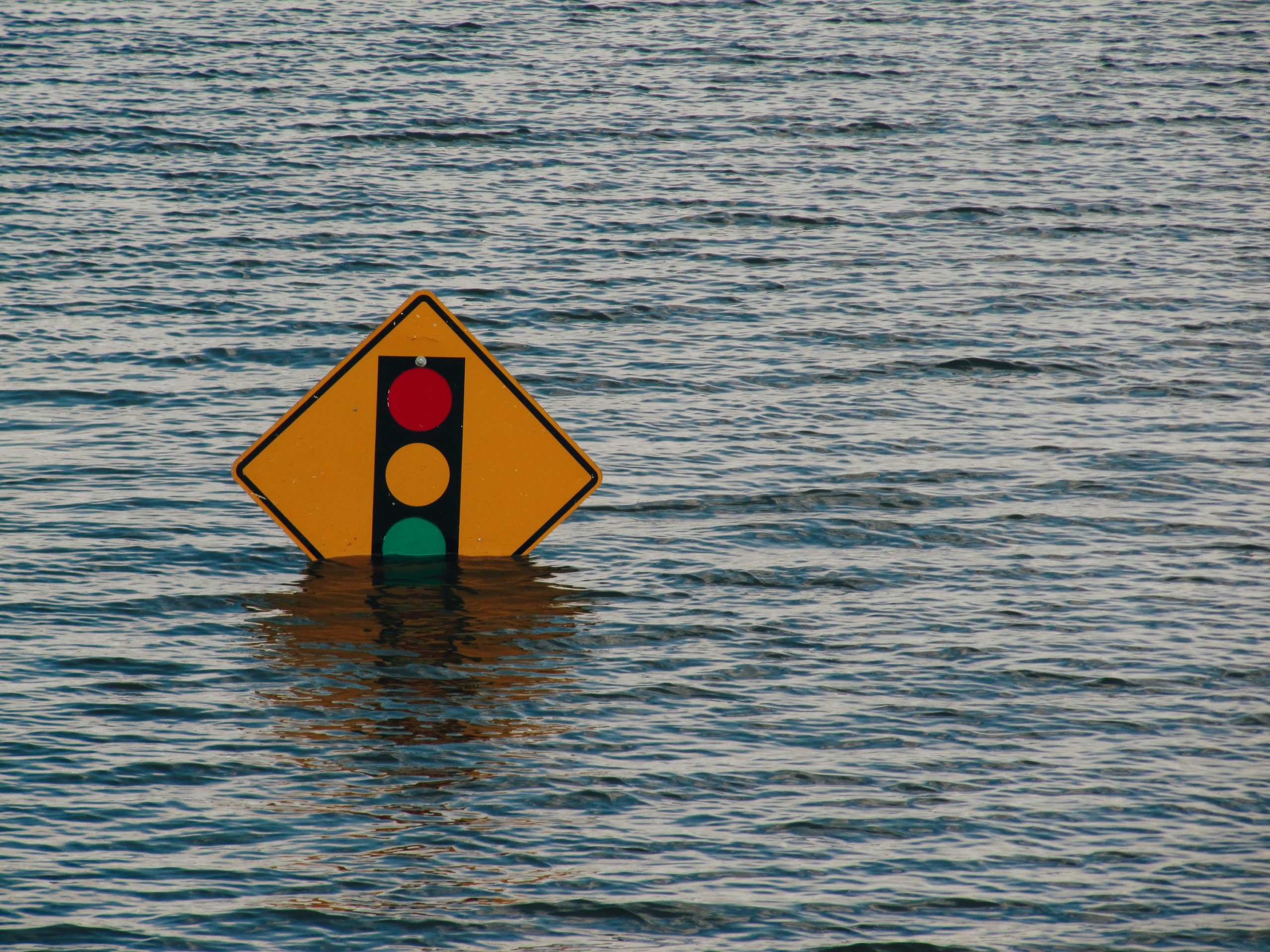 stop light ahead sign in water due to flooding