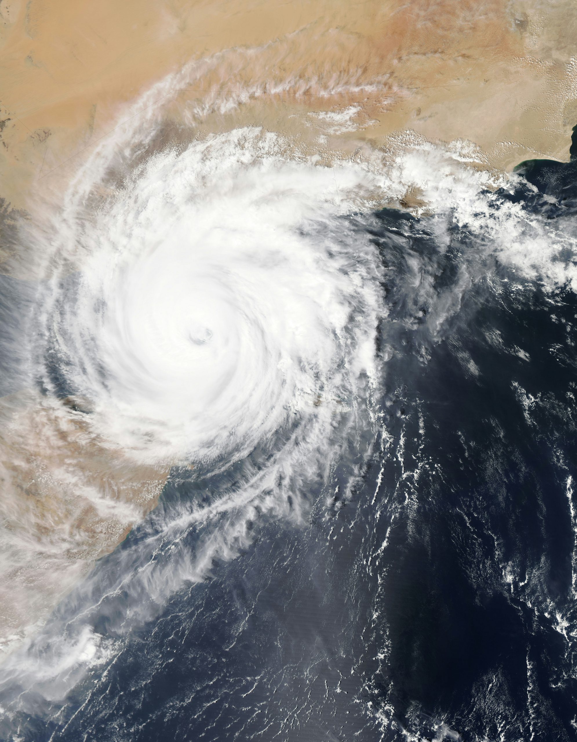aerial showing the eye of a hurricane moving onto land from the sea