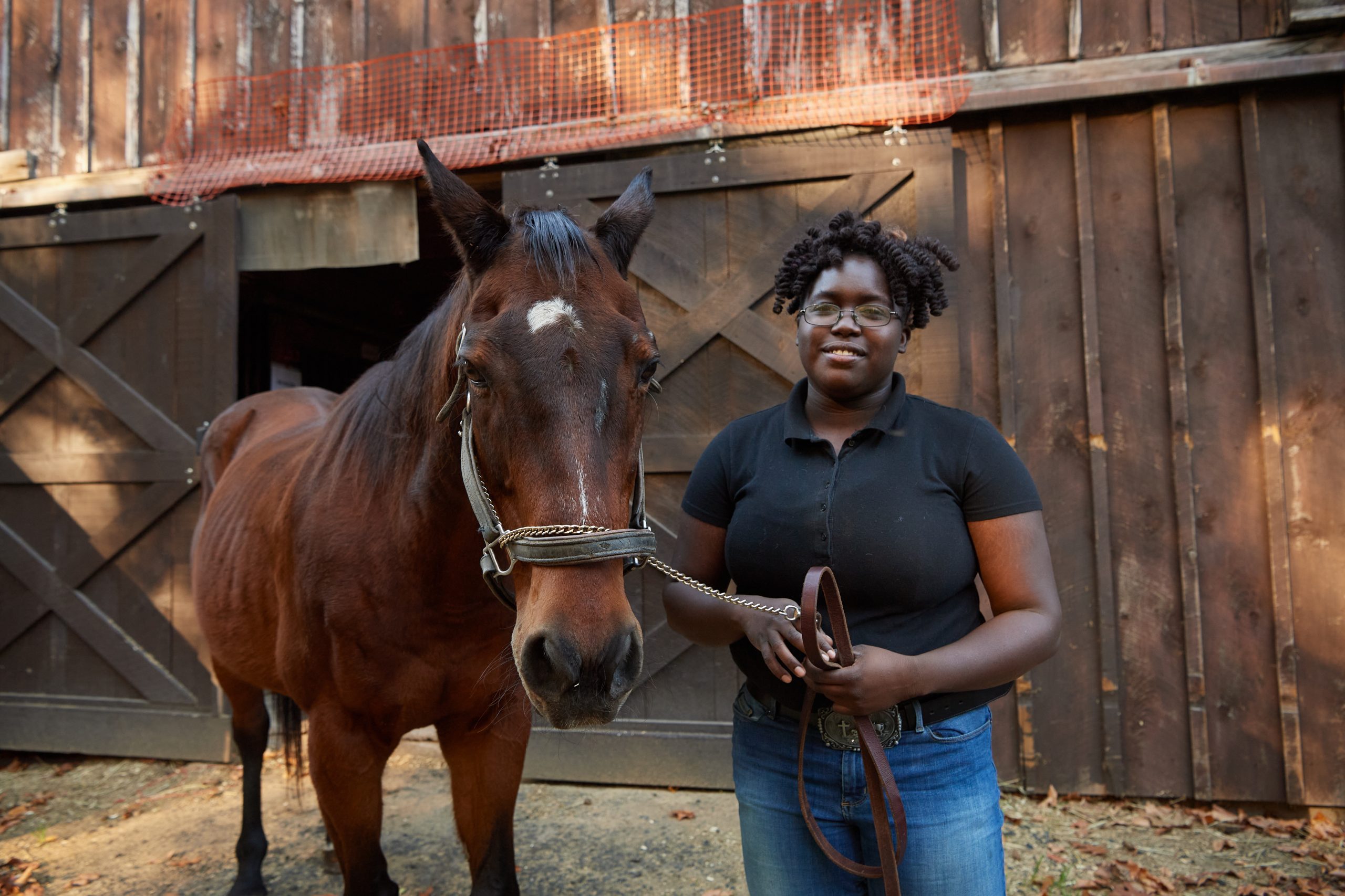 LaShawnda Phillips '20 (RHSA) '22 (CAHNR), with a horse named Handsome, at the Ebony Horsewomen Incorporated Equestrian and Therapeutic Center in Hartford on Nov. 8, 2021. (Peter Morenus/UConn Photo)