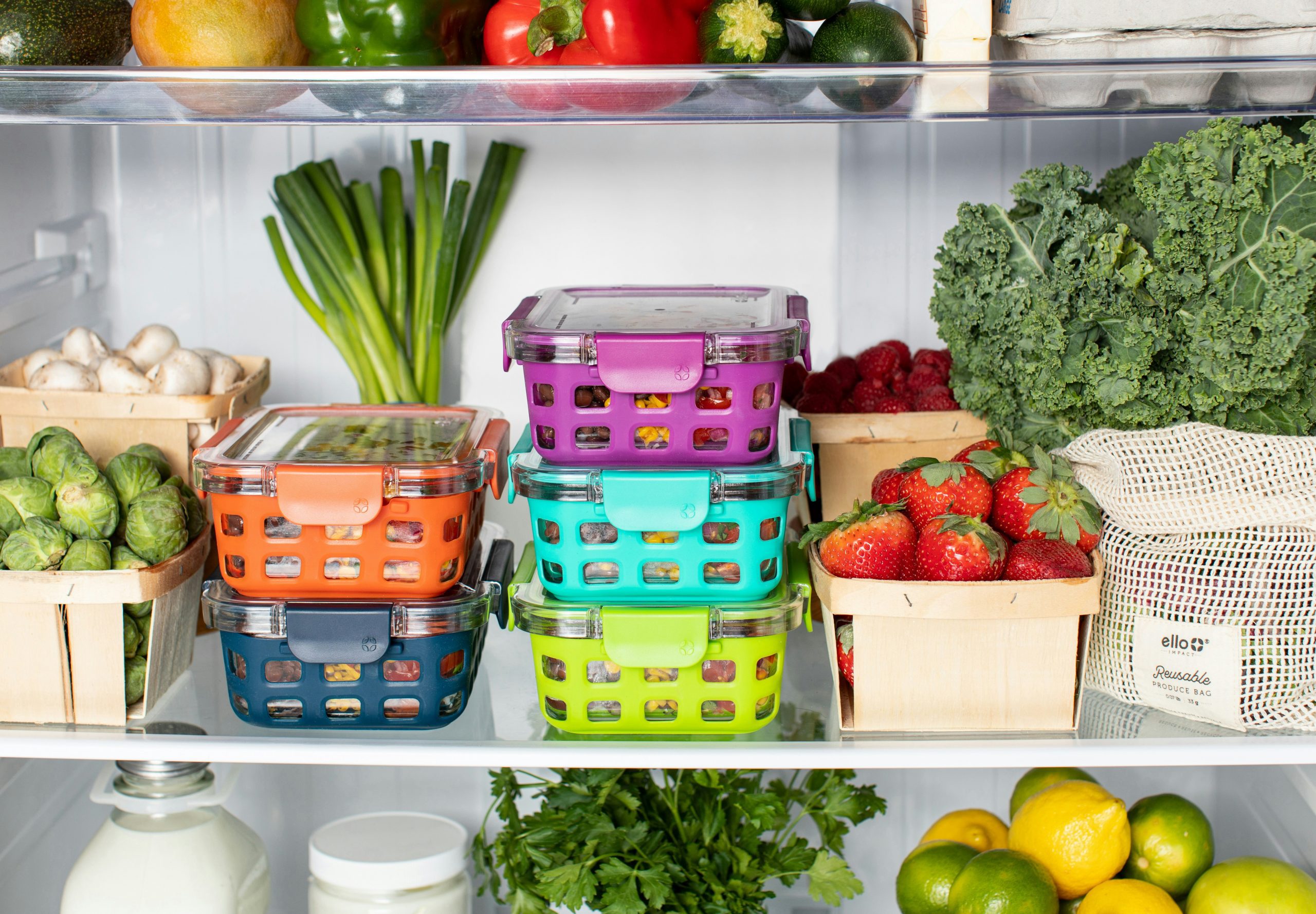 the inside of a refrigerator with lots of fresh fruits and vegetables and containers of leftovers