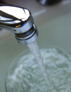 Water running from a faucet into a cup