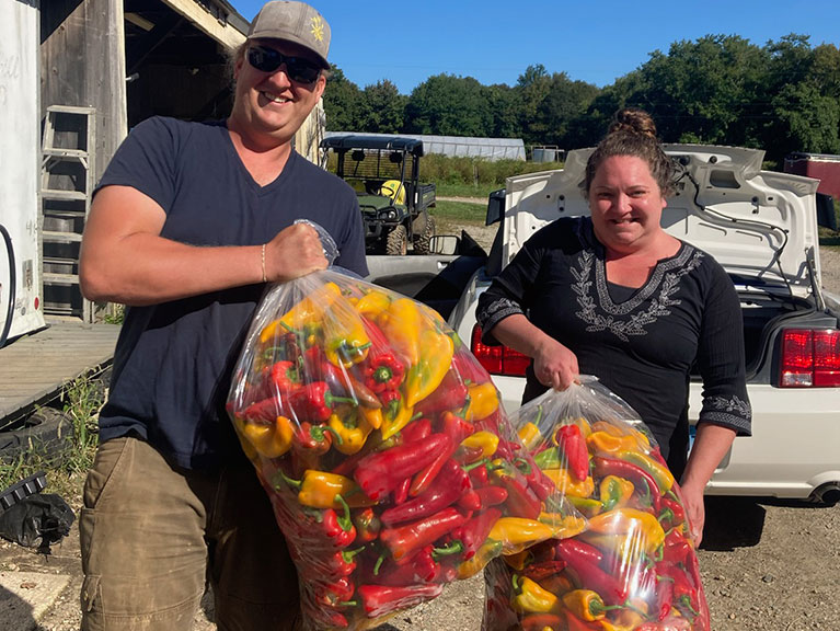 couple holding bags of peppers