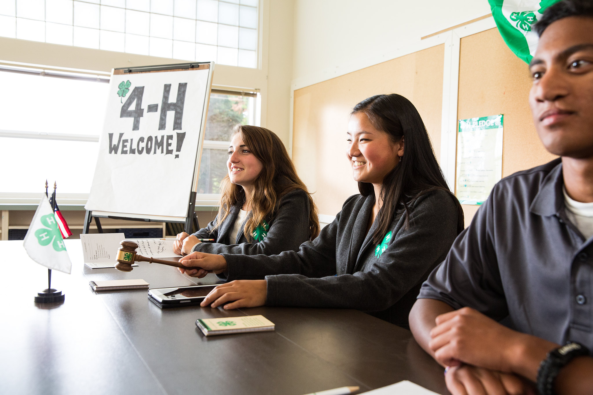 three 4-H teens sitting at a table leading a meeting