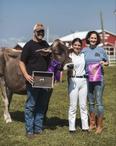 David Buck and Tamra French with one of their 4-H members and her Brown Swiss heifer at the 4-H fair