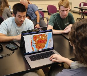 students at a computer looking at a map